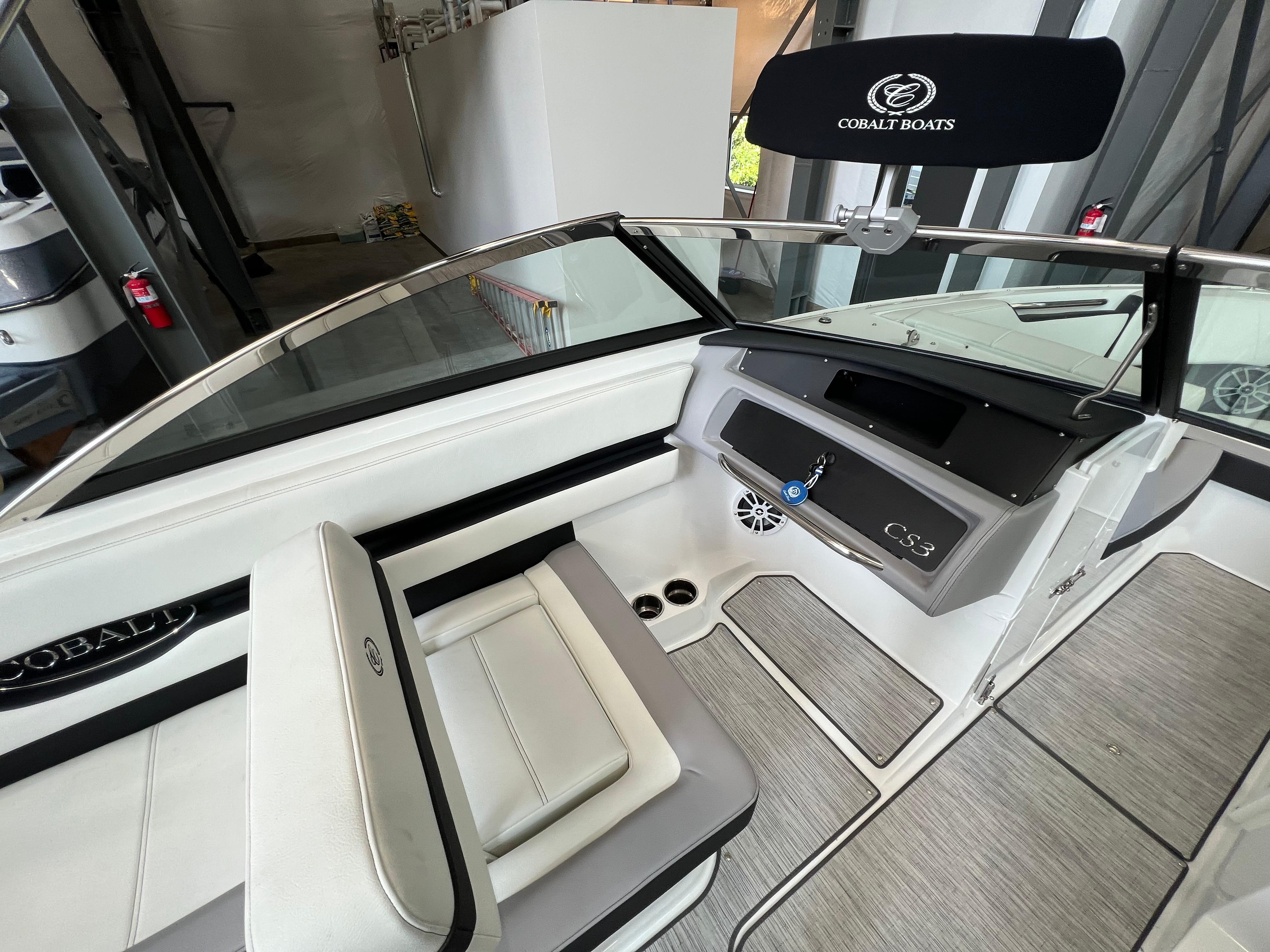 Slide: The Image of 2023 Cobalt CS23 Surf boat interior with white seating and modern dashboard. - 12