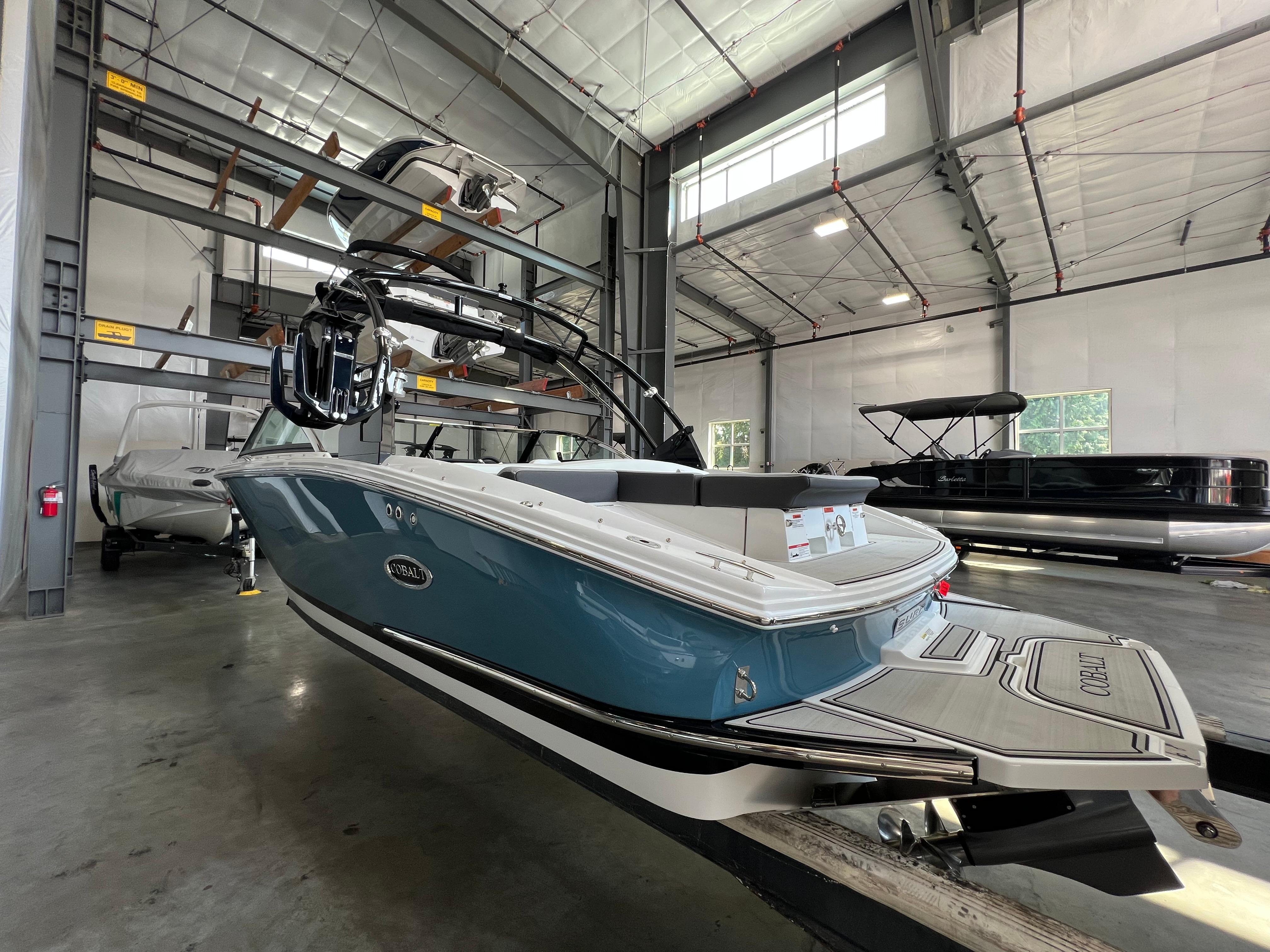 Slide: The Image of 2023 Cobalt CS23 Surf boat in a showroom, rear view. - 3