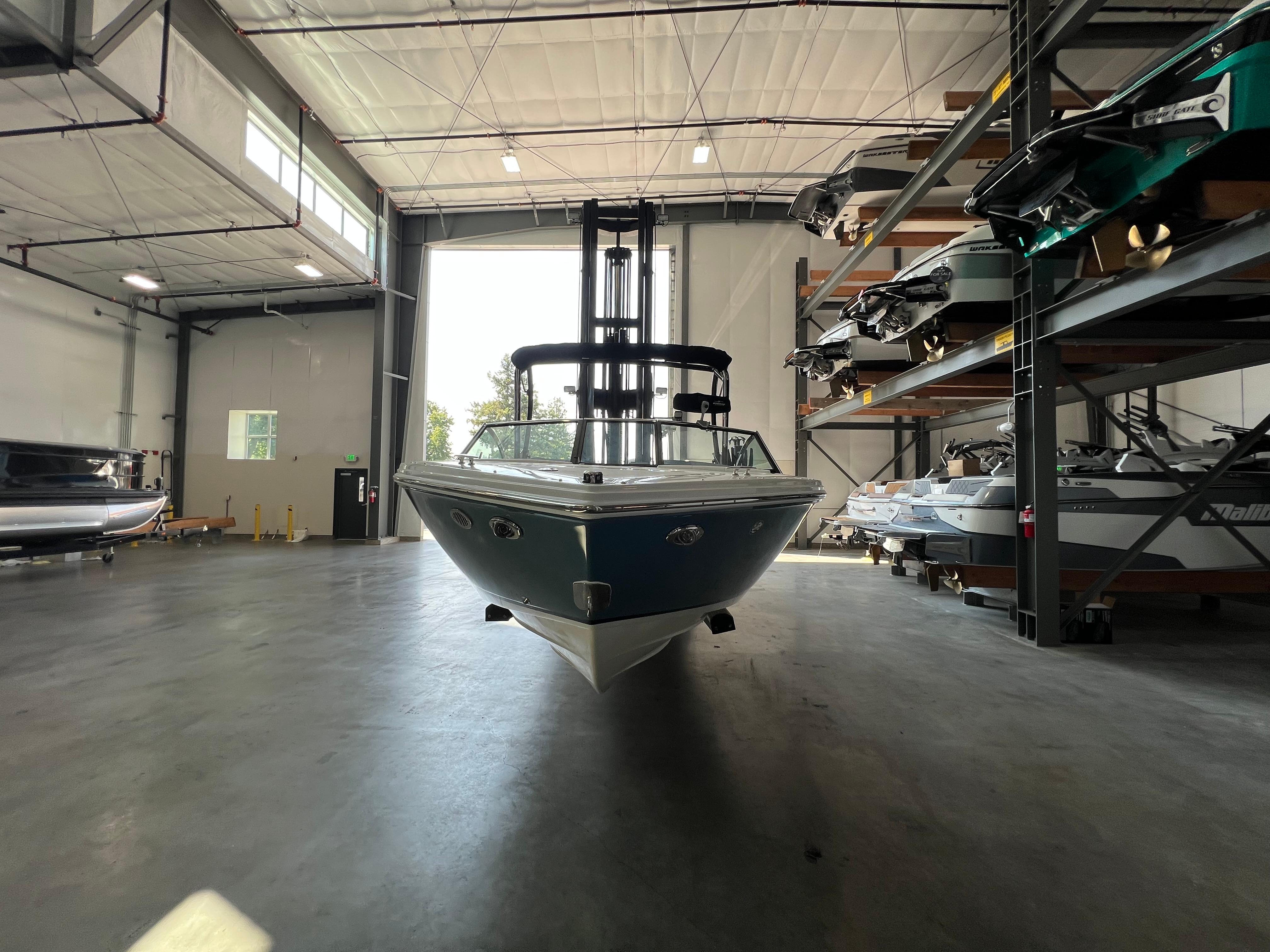 Slide: The Image of 2023 Cobalt CS23 Surf boat in a spacious indoor storage facility. - 7