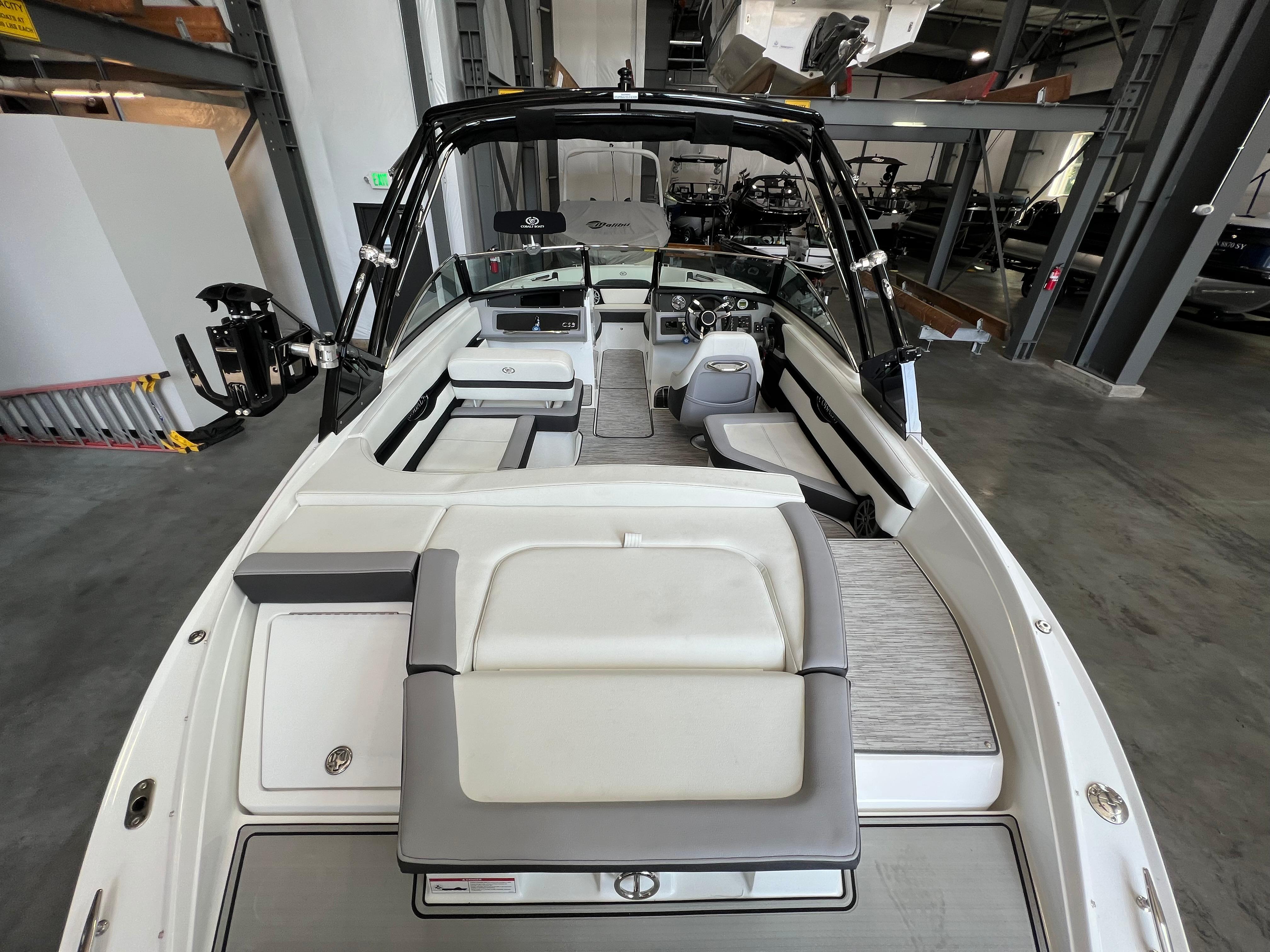 Slide: The Image of 2023 Cobalt CS23 Surf boat interior with seating and control panel in showroom. - 8