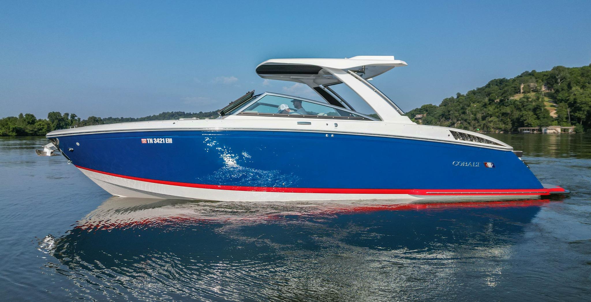 Slide: The Image of 2023 Cobalt R33 boat on calm water, blue and white design, side view. - 10