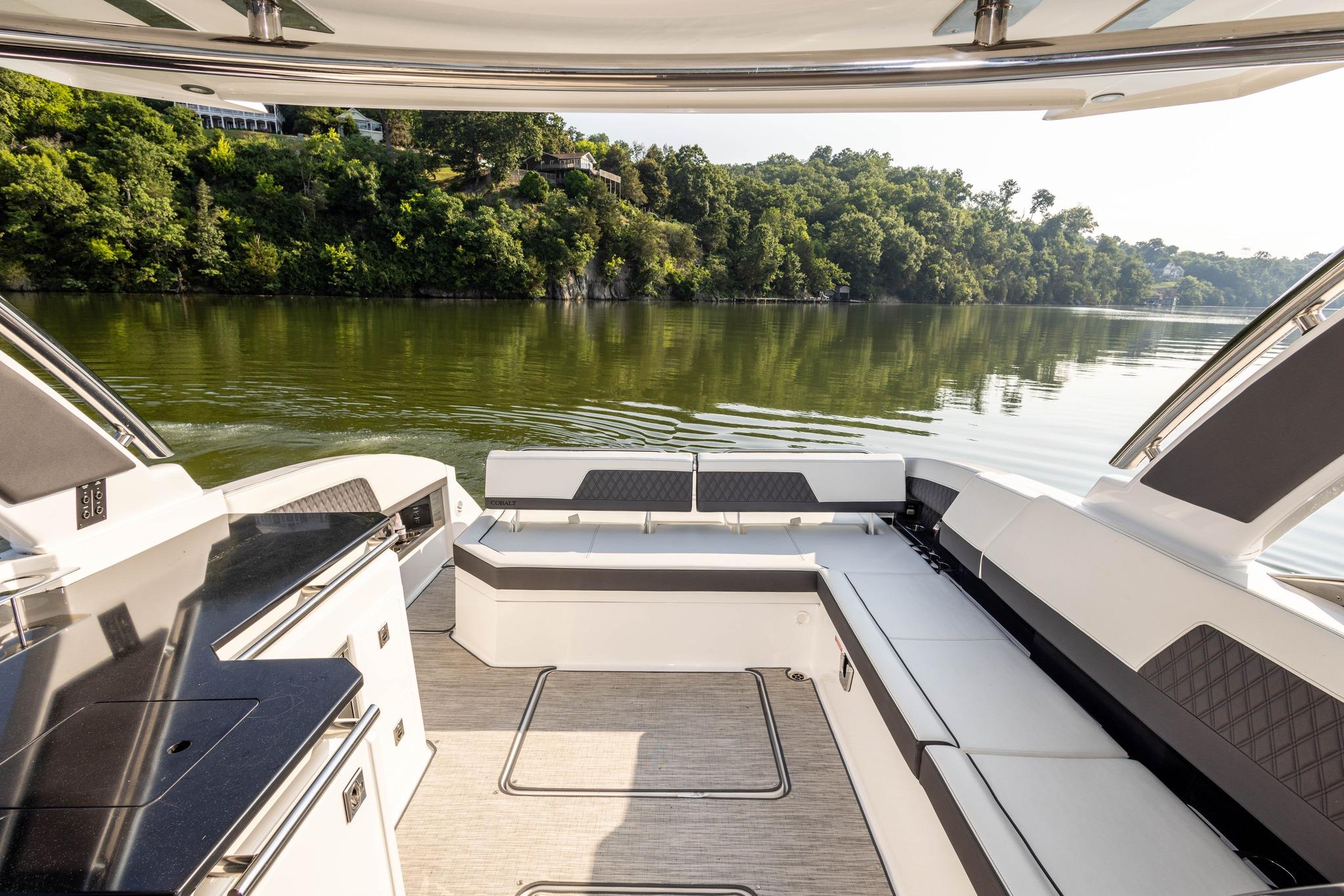 Slide: The Image of Luxurious 2023 Cobalt R33 boat interior with scenic lake view and lush greenery. - 19