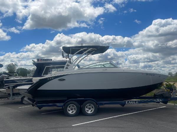 Slide: The Image of 2021 Cobalt R5 Surf boat on trailer under a cloudy blue sky. - 0