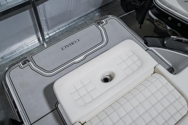 Slide: The Image of 2021 Cobalt R5 Surf boat interior with white cushioned seating and branded flooring. - 6