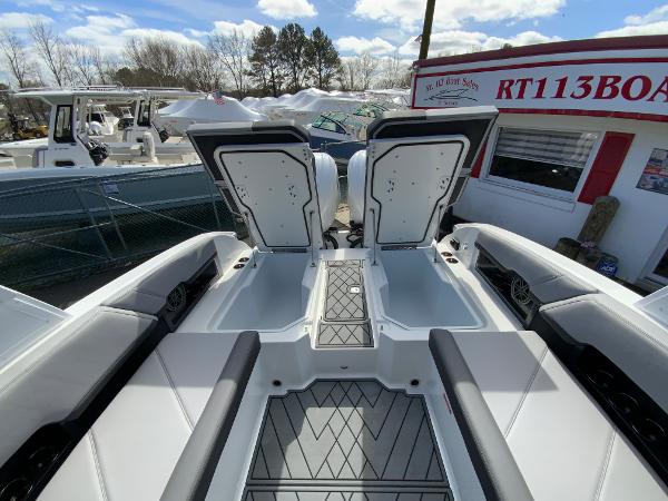Slide: The Image of 2024 Cobalt R8 Outboard boat with open storage compartments at a dealership. - 15