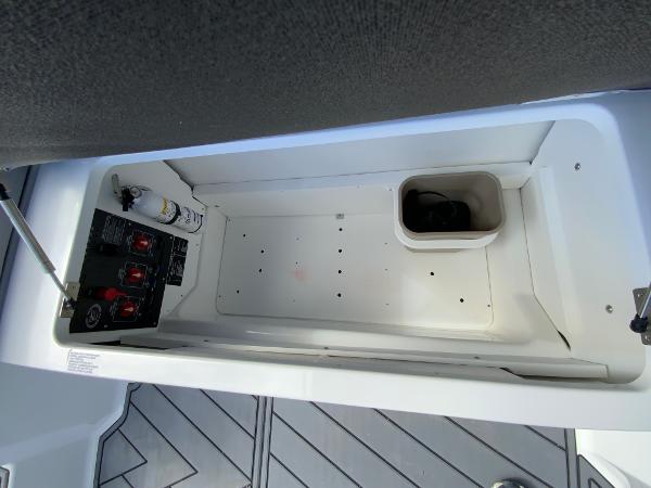 Slide: The Image of 2024 Cobalt R8 Outboard storage compartment with control panel and fire extinguisher. - 21