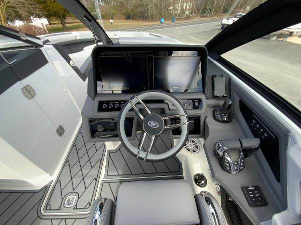 Slide: The Image of 2024 Cobalt R8 Outboard boat cockpit with modern steering wheel and dual screens. - 30