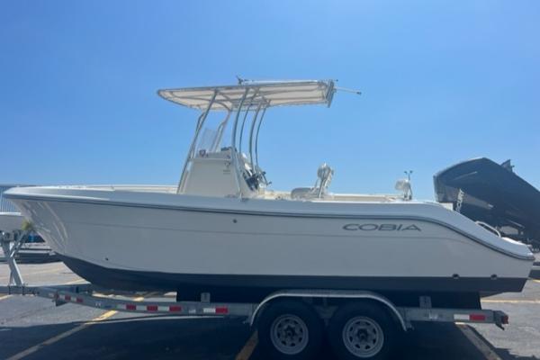 Slide: The Image of 2020 Cobia 237CC boat on a trailer under a clear blue sky. - 0