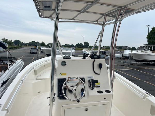 Slide: The Image of 2020 Cobia 237CC center console boat with T-top in a marina. - 3