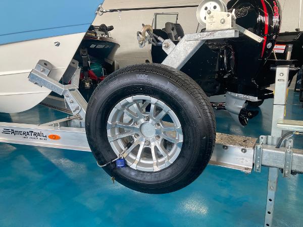 Slide: The Image of Trailer wheel of a 2022 Cobia 240 DC boat on AmeraTrail trailer in a showroom. - 18