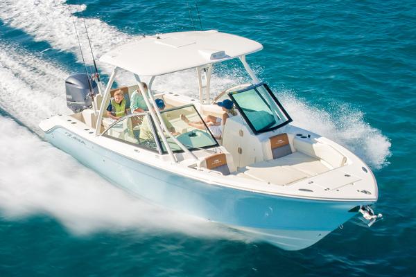 Slide: The Image of Manufacturer Provided Image: 2023 Cobia 240 Dual Console boat cruising on clear blue water. - 0