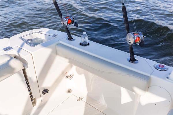 Slide: The Image of Manufacturer Provided Image: 2023 Cobia 240 Dual Console boat with fishing rods and water bottle. - 16
