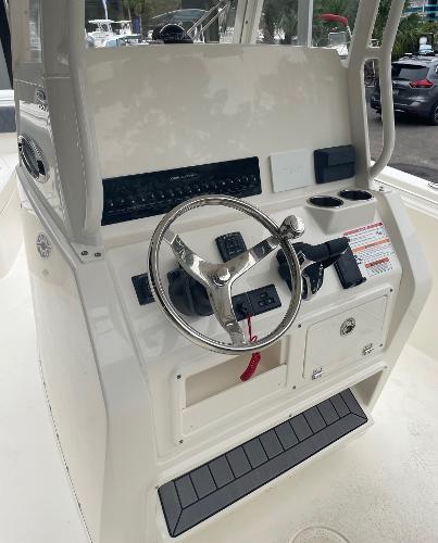 Slide: The Image of 2024 Cobia 262 Center Console boat helm with steering wheel and control panel. - 4