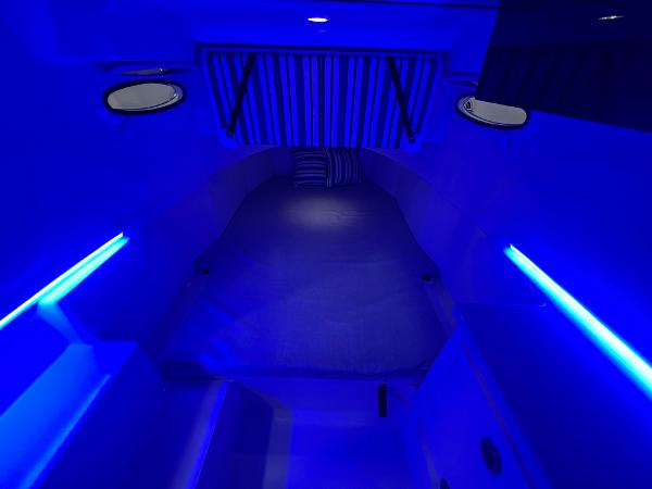 Slide: The Image of 2023 Cobia 350 Center Console cabin with blue LED lighting. - 23