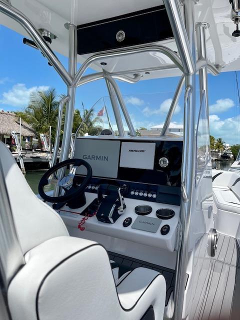 Slide: The Image of 2023 Concept 27 boat helm with Garmin and Mercury displays, docked under clear blue sky. - 1