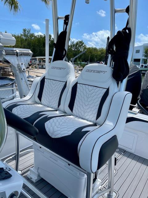 Slide: The Image of Luxury seating on 2023 Concept 27 boat, white and black upholstery, docked marina background. - 4