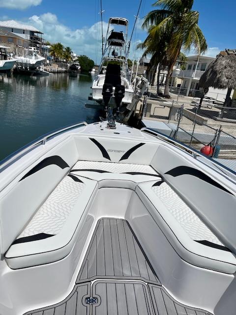 Slide: The Image of Concept 27 boat 2023 model docked in a sunny marina with palm trees. - 5