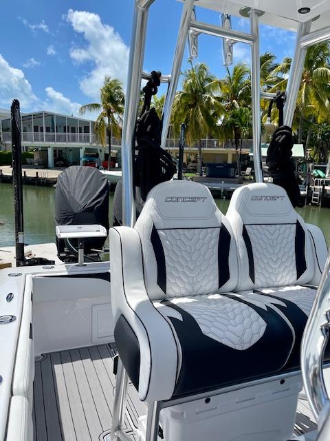 Slide: The Image of Luxury seating on 2023 Concept 27 boat docked by palm trees and waterfront homes. - 7