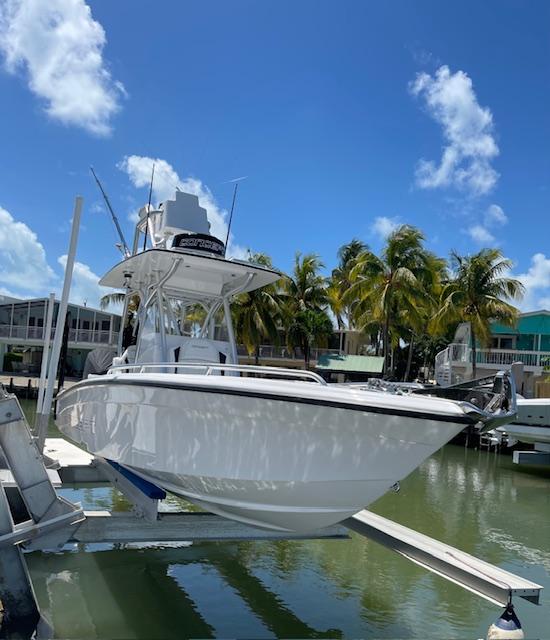 Slide: The Image of 2023 Concept 27 boat docked in a tropical marina with palm trees. - 8