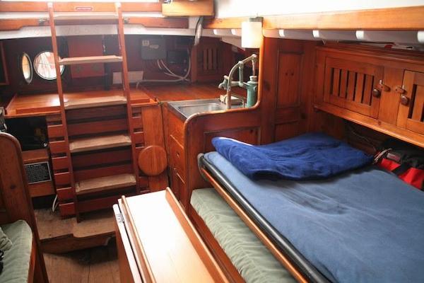 Slide: The Image of 1958 Concordia Yawl interior with wooden furnishings, bed, and compact kitchen area. - 18