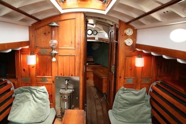 Slide: The Image of Interior of a 1958 Concordia Yawl sailboat with wooden paneling and cozy seating. - 20