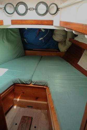 Slide: The Image of 1958 Concordia Yawl cabin interior with green cushions and wooden trim. - 7