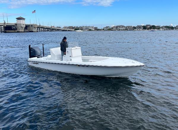 Slide: The Image of 2022 Contender 25 Bay boat cruising on a calm waterway near a bridge. - 0
