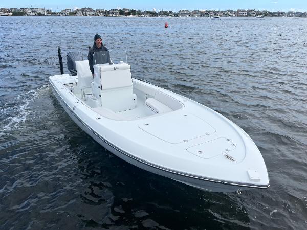 Slide: The Image of 2022 Contender 25 Bay boat cruising on water with a person at the helm. - 1