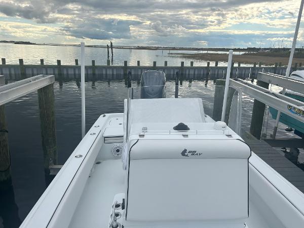 Slide: The Image of 2022 Contender 25 Bay boat docked at a marina with a scenic water view. - 11