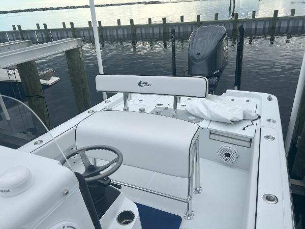 Slide: The Image of 2022 Contender 25 Bay boat docked, featuring a clean white interior and outboard motor. - 12