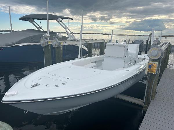 Slide: The Image of 2022 Contender 25 Bay boat docked at marina under cloudy sky. - 15