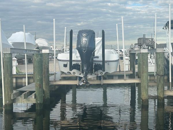 Slide: The Image of 2022 Contender 25 Bay boat docked at a marina with a Yamaha outboard motor. - 16