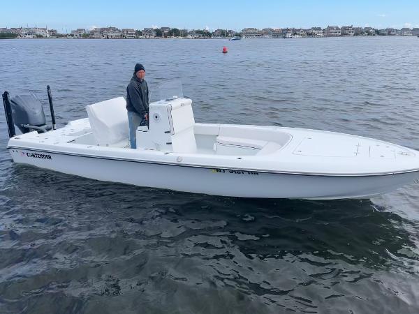 Slide: The Image of 2022 Contender 25 Bay boat on water with a person at the helm. - 6