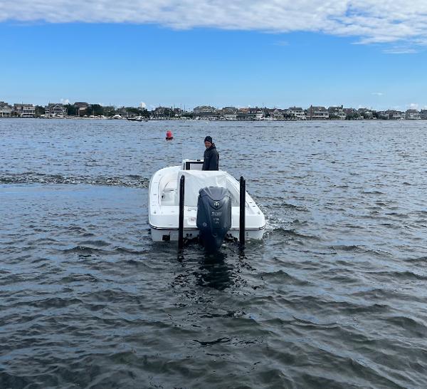 Slide: The Image of 2022 Contender 25 Bay boat on water with person at helm. - 7