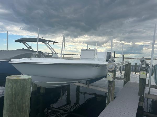 Slide: The Image of 2022 Contender 25 Bay boat docked at marina under cloudy sky. - 8