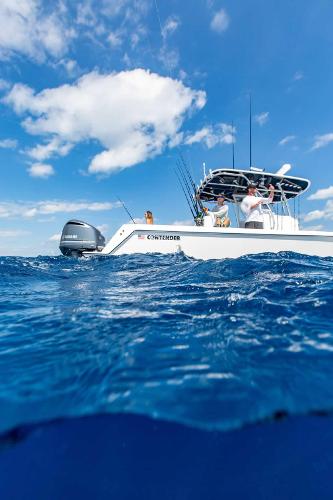 Slide: The Image of 2025 Contender 32 ST boat on open water under blue sky. - 13