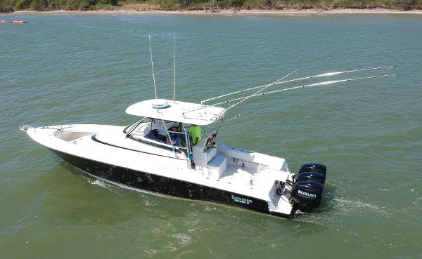 Slide: The Image of 2008 Contender 36 Fish Around boat cruising on water with dual Suzuki outboard engines. - 28