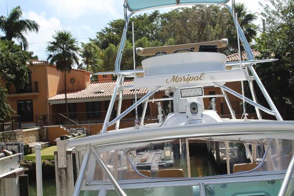 Slide: The Image of Contender 38 Express 2008 boat docked near a waterfront house with palm trees. - 2