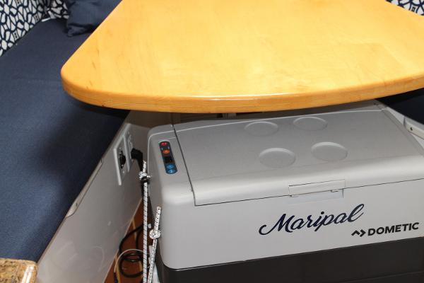 Slide: The Image of Interior of 2008 Contender 38 Express with Dometic cooler under wooden table. - 41