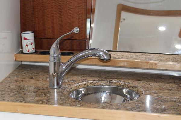 Slide: The Image of 2008 Contender 38 Express boat kitchen sink with granite countertop and chrome faucet. - 48