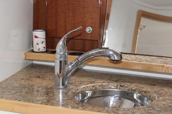 Slide: The Image of Contender 38 Express 2008 boat interior sink with chrome faucet and granite countertop. - 49