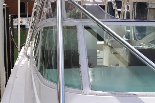 Slide: The Image of 2008 Contender 38 Express boat docked, close-up of the cabin windows and railing. - 5