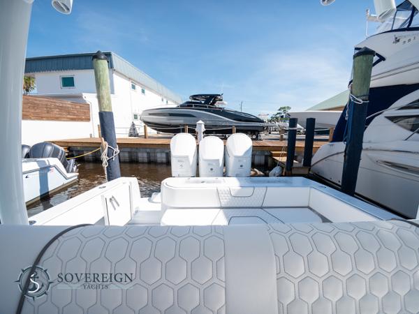 Slide: The Image of 2024 Contender 44 CB boat docked at a marina with triple outboard engines. - 11