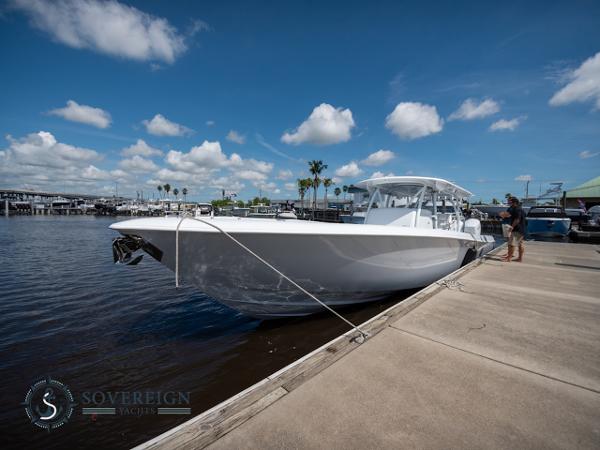 Slide: The Image of 2024 Contender 44 CB boat docked at a marina under a clear blue sky. - 38