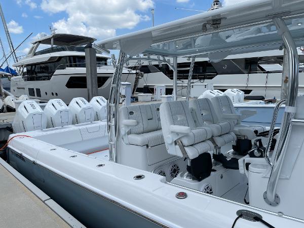 Slide: The Image of 2025 Contender 44ST boat docked, featuring multiple outboard engines and luxurious seating. - 12