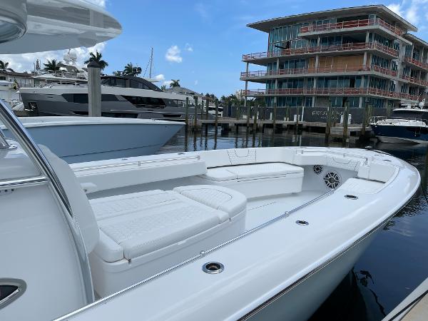 Slide: The Image of Contender 2025 44ST boat docked at marina with modern buildings in background. - 13