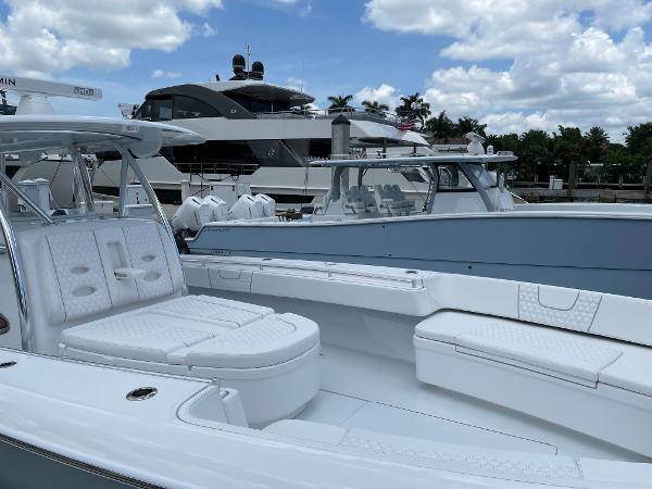 Slide: The Image of Contender 2025 44ST boat with luxurious seating, docked near other yachts. - 14