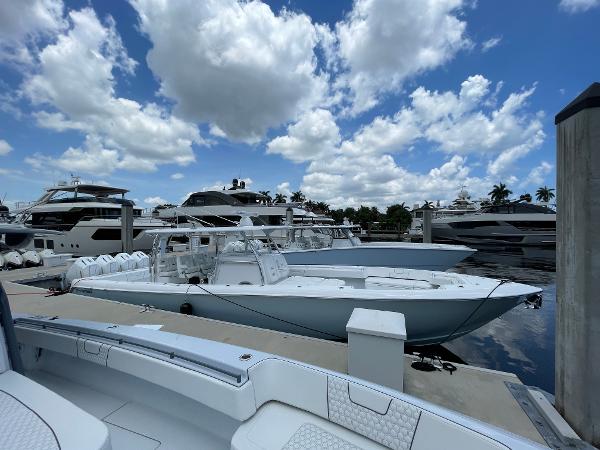 Slide: The Image of Contender 2025 44ST boats docked at a marina under a partly cloudy sky. - 18