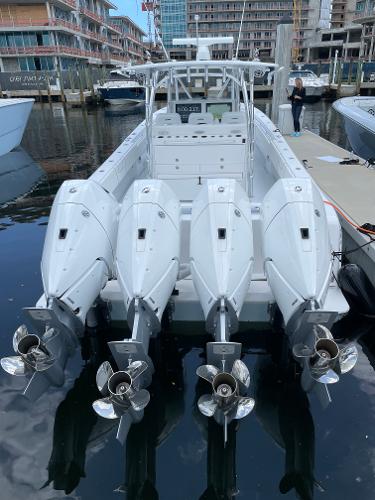 Slide: The Image of 2025 Contender 44ST boat with triple outboard engines docked at marina. - 2