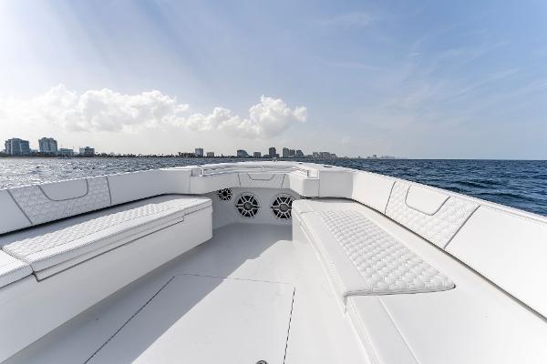 Slide: The Image of Contender 2025 44ST boat with white seating, ocean view, and city skyline in the background. - 20
